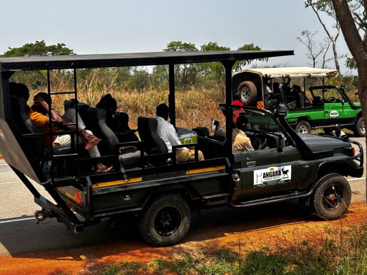An open 4x4 Angara safari jeep taking tourists on a game drives inside Murchison falls national park