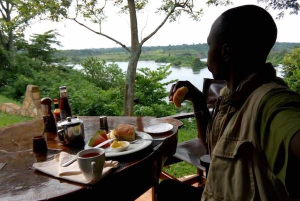 A tourist having breakfast at the river Nile source in Murchison falls national park